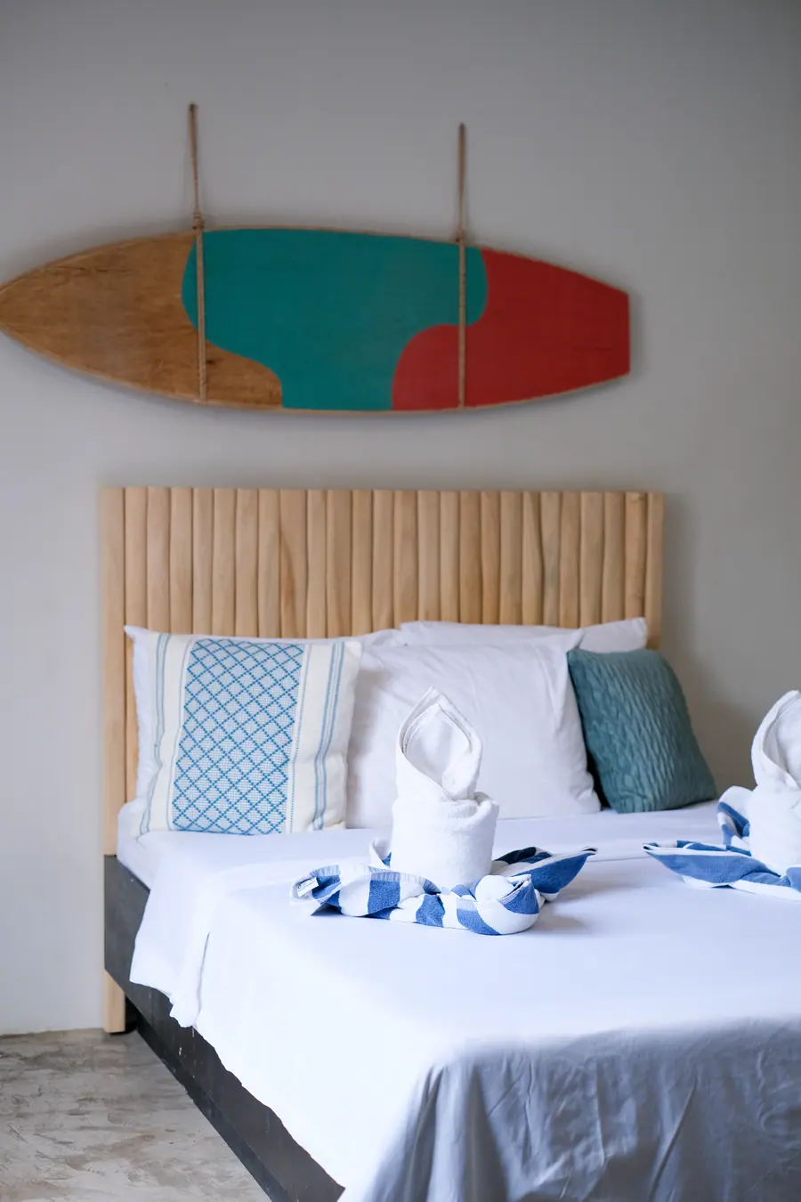 A Superior room at Siargao Bed & Brewery, with a wooden headboard and a surfboard on the wall
